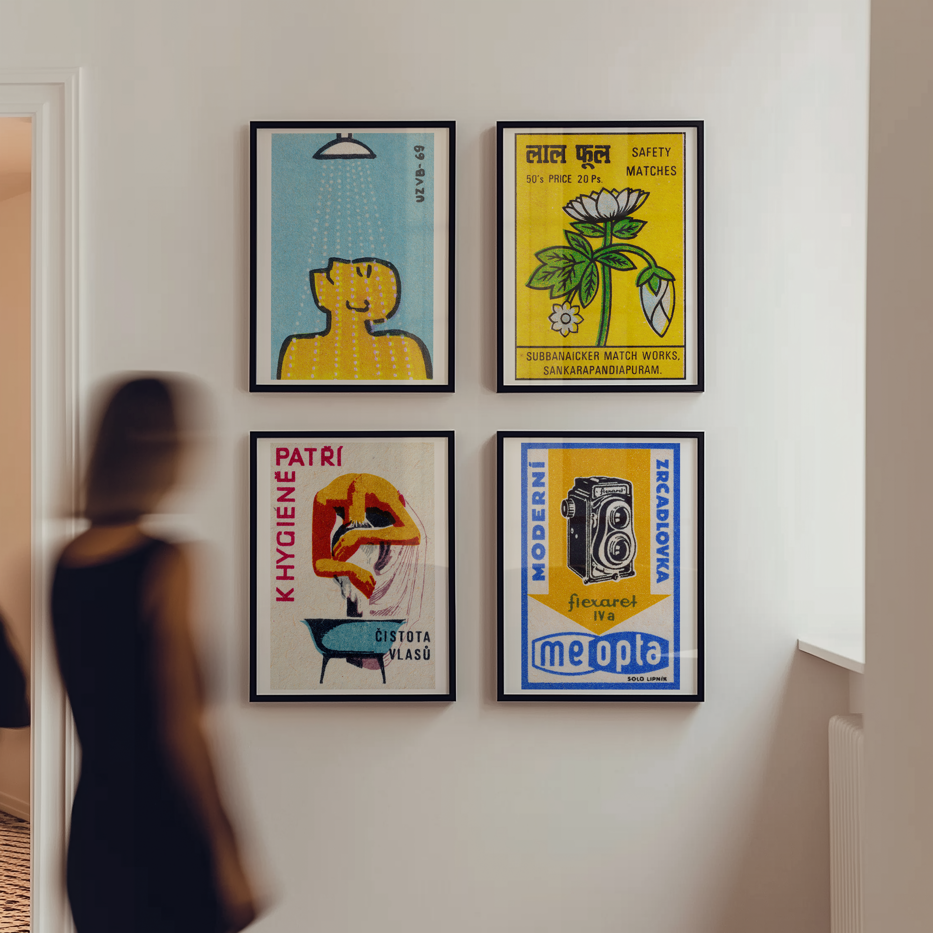 Four framed posters on a wall with a person partially visible in the foreground.